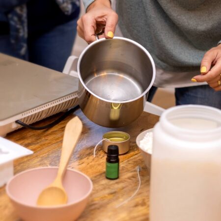 Žena na slici koristi sastojke i materijale prikupljenje za pravljenje sveće kod kuće.