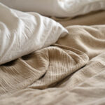 Slika pokazuje izgužvani stari čaršaf pored jastuka.